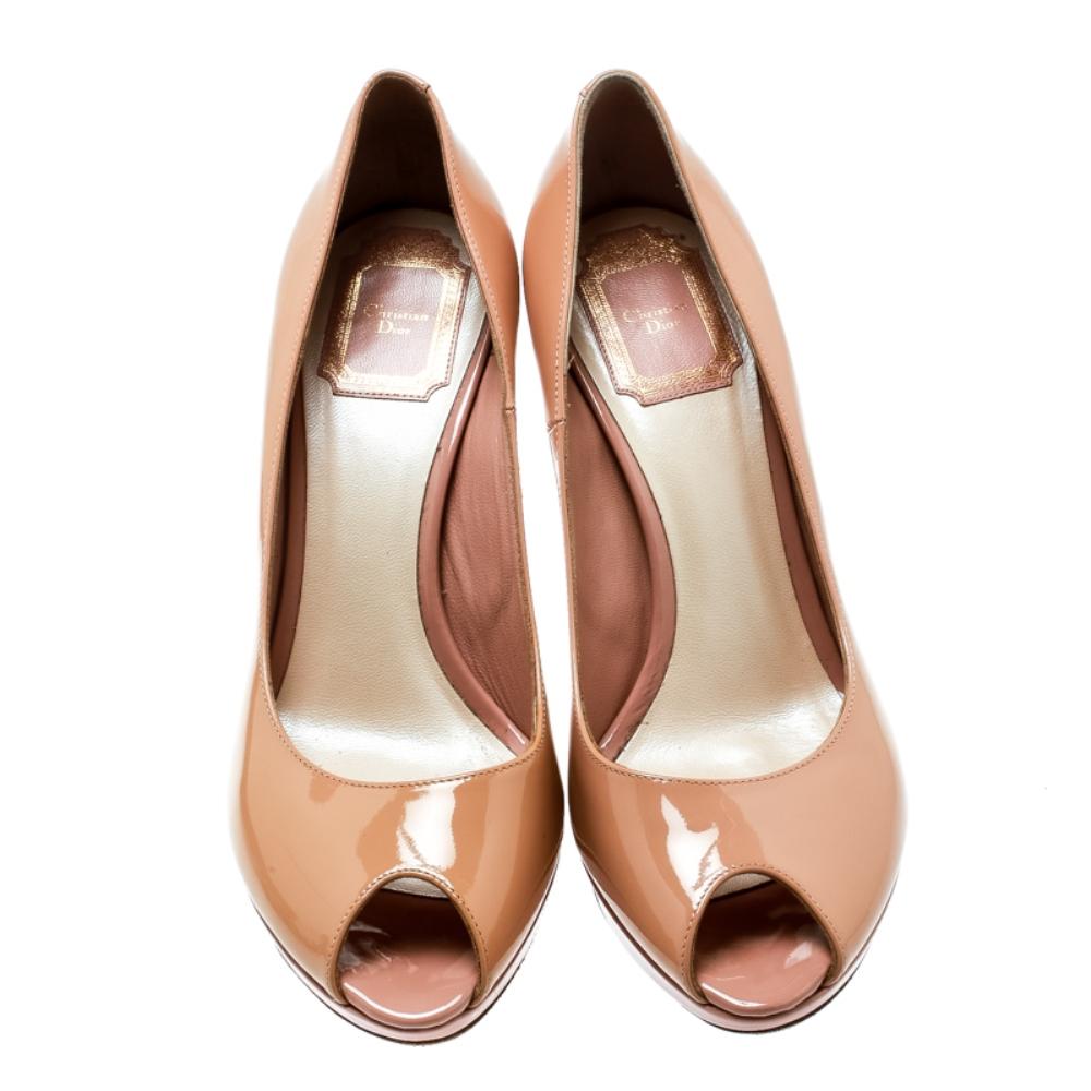 Turn heads as you walk around in this pair of Miss Dior pumps by Dior. Crafted from beige patent leather, the pair features platforms, feminine peep-toes and 10.5 cm high stiletto heels. Finished with logo plaque on the counters, these beauties are