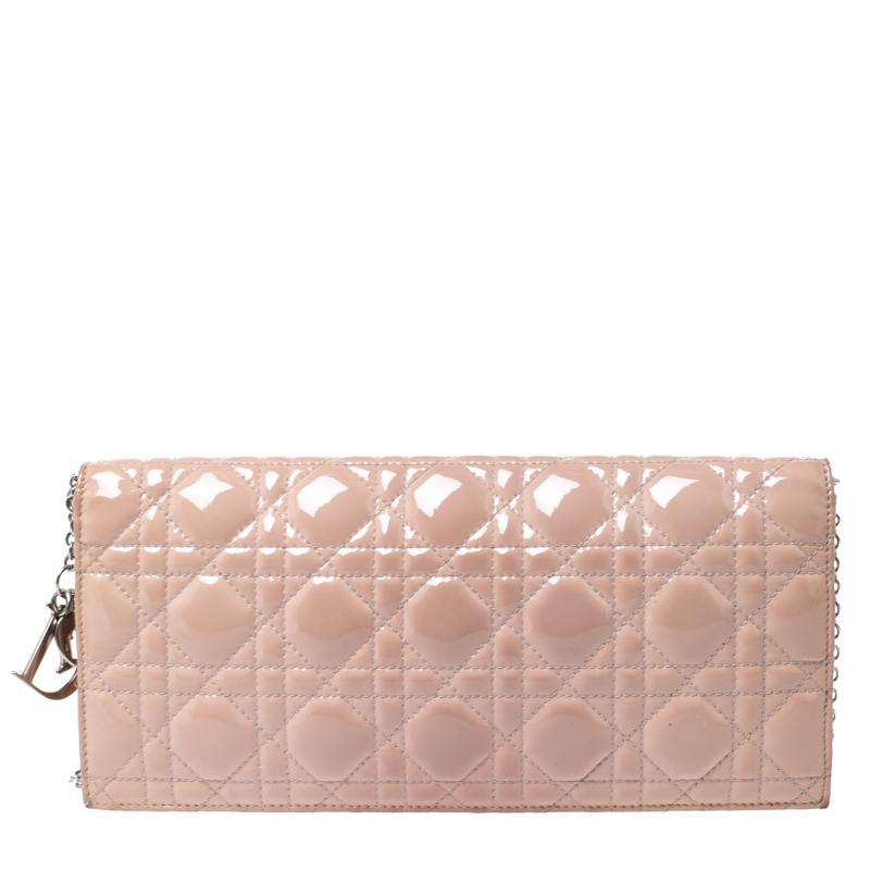 This Lady Dior wallet is a coveted bag that every fashionista craves to possess. This beige clutch has been crafted from patent leather and it carries the signature Cannage quilt. It is equipped with a nylon interior featuring a slip pocket and an