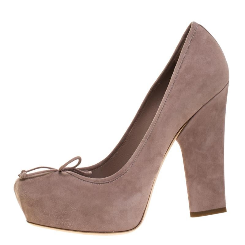 Look chic and make an elegant style statement with this pair of suede pumps. From the house of Dior, this pair is designed with petite bows on the vamps and high block heels. In a remarkable shade of beige, you can wear these pumps for both work and