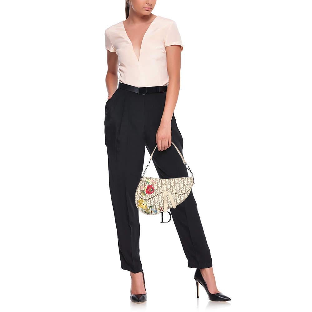 An example of timeless style and great design ideas  Diors Saddle bag is sought after for all the right reasons. This Saddle bag for women is crafted using Oblique canvas and leather in the iconic shape and it has silver tone CD letters to hold the