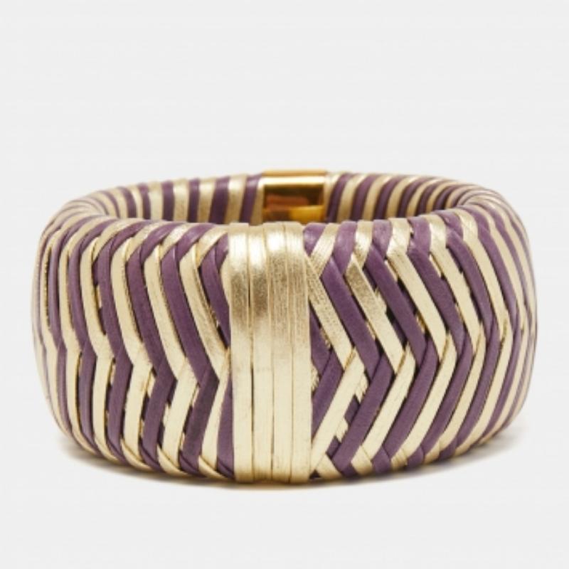 Questo braccialetto in pelle Dior è disponibile in due colori. Realizzato in pelle, ha un design intrecciato a forma di chevron rifinito con un accento in metallo dorato che riporta il nome del marchio.