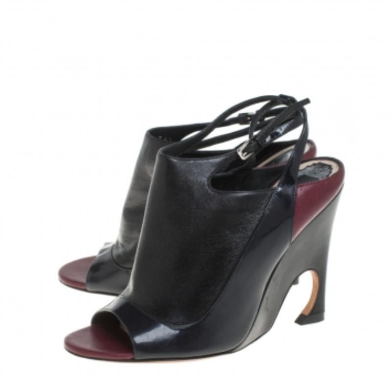 Schlüpfen Sie in diese umwerfenden Sandalen von Dior und sehen Sie aus wie eine Fashionista! Sie sind aus Leder und Lackleder gefertigt und zeichnen sich durch Schwarz- und Burgundertöne, offene Zehen und Schnallenriemen aus. Die geschwungenen