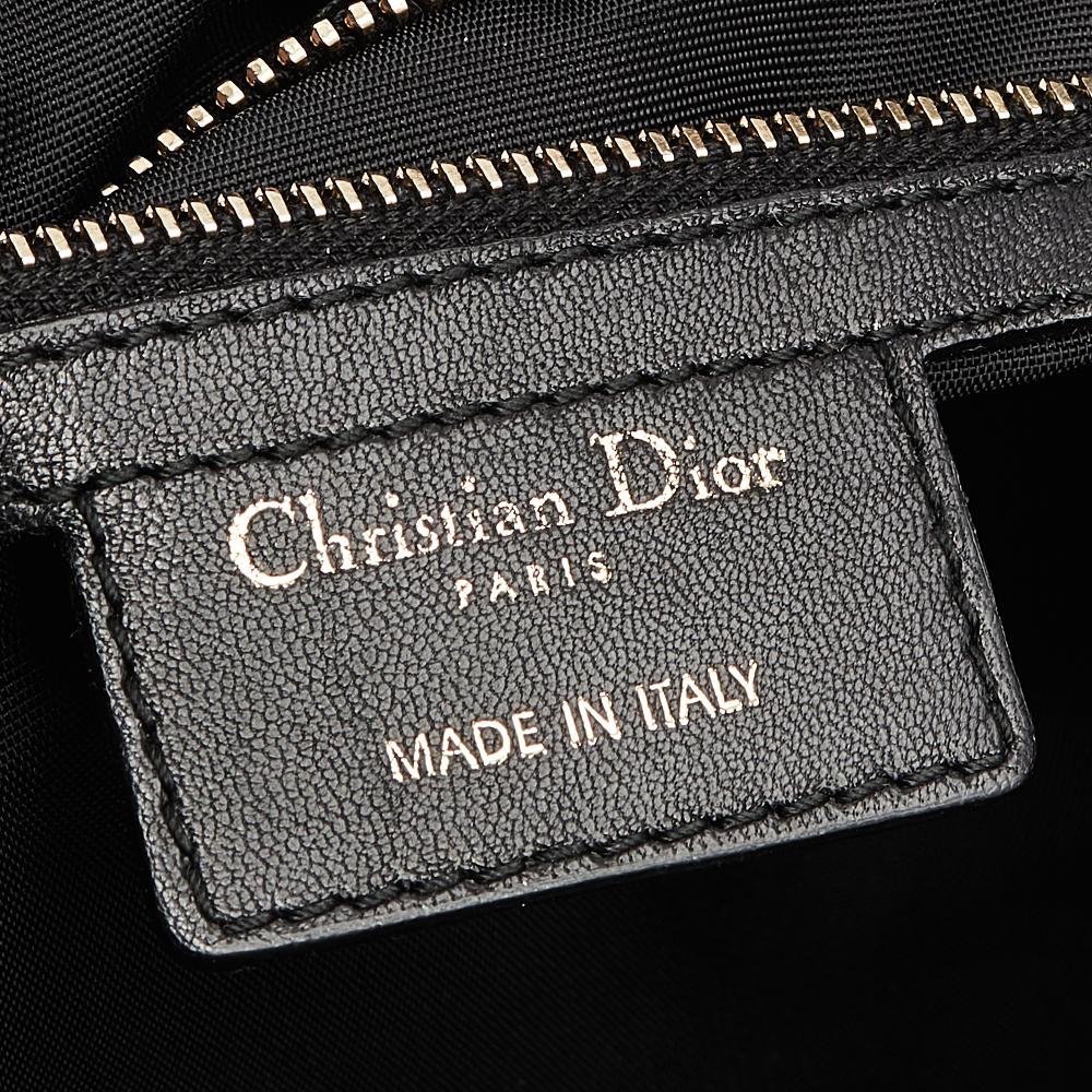This Dior satchel is a timeless handbag that you will love for years to come. This creation is made from Cannage-quilted leather with patent leather trims and two side drawstring pockets. The sturdy rolled handles and nylon-lined interior make this