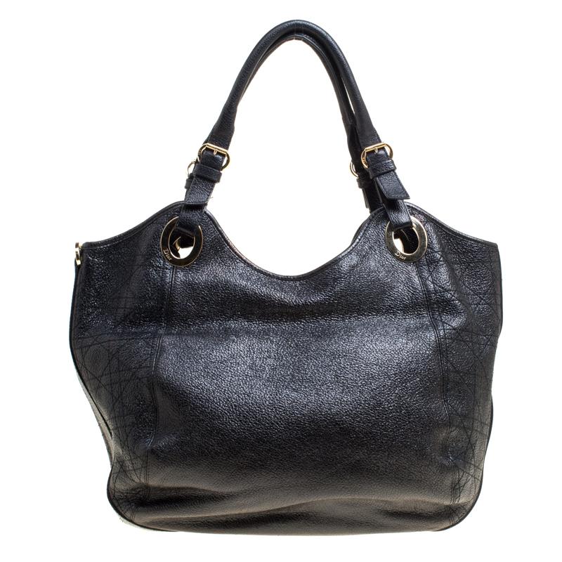 You'll surely love owning this Dior tote as it is stylish and functional. It has been crafted from black leather and styled with Cannage patterns, two handles, front pocket and Dior letter charms. The bag is complete with a spacious fabric interior