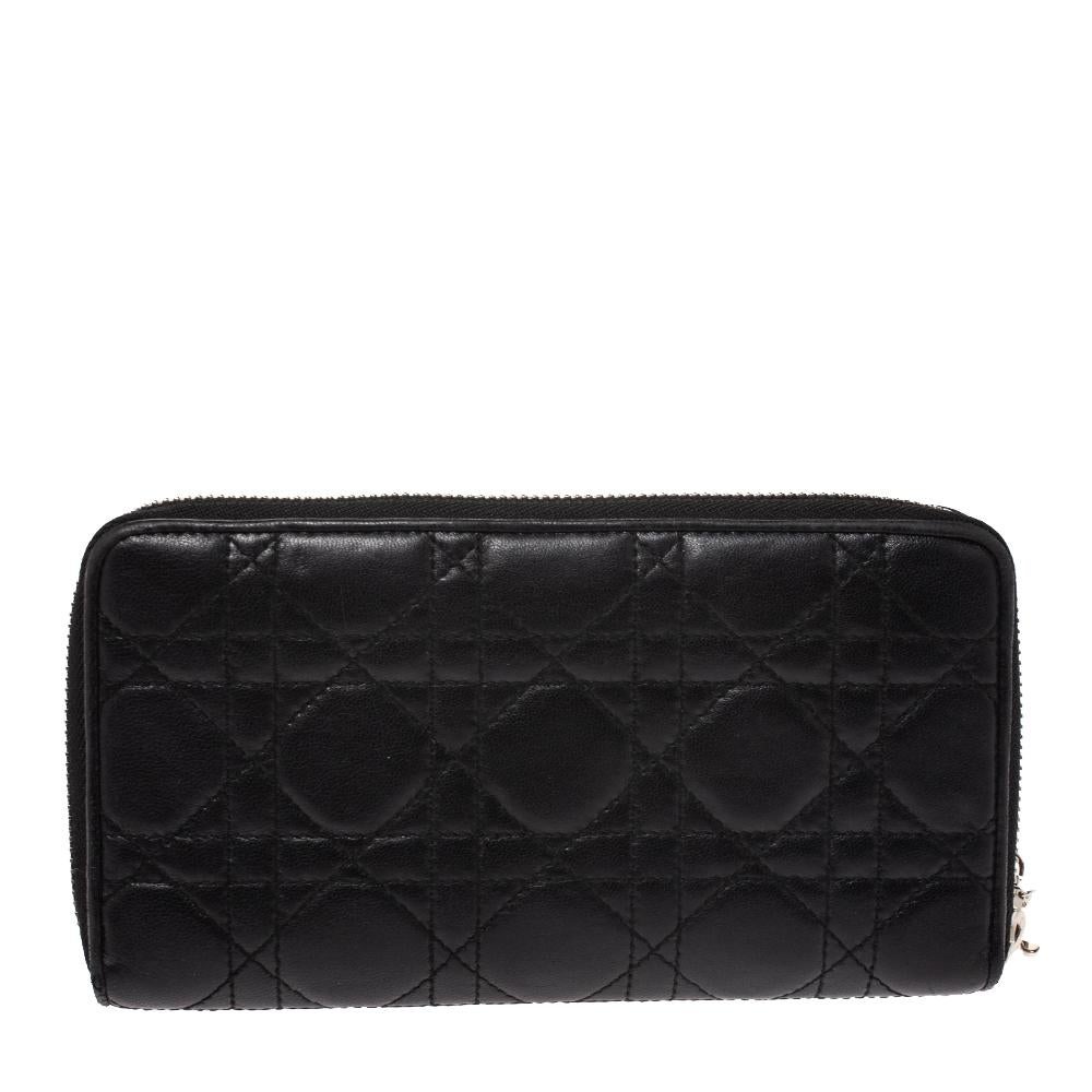 This Lady Dior wallet is conveniently designed for everyday use. Crafted from leather, the exterior has a quilted Cannage pattern and a zipper with DIOR letter charms on the zipper pull. The leather and fabric-lined interior houses multiple card