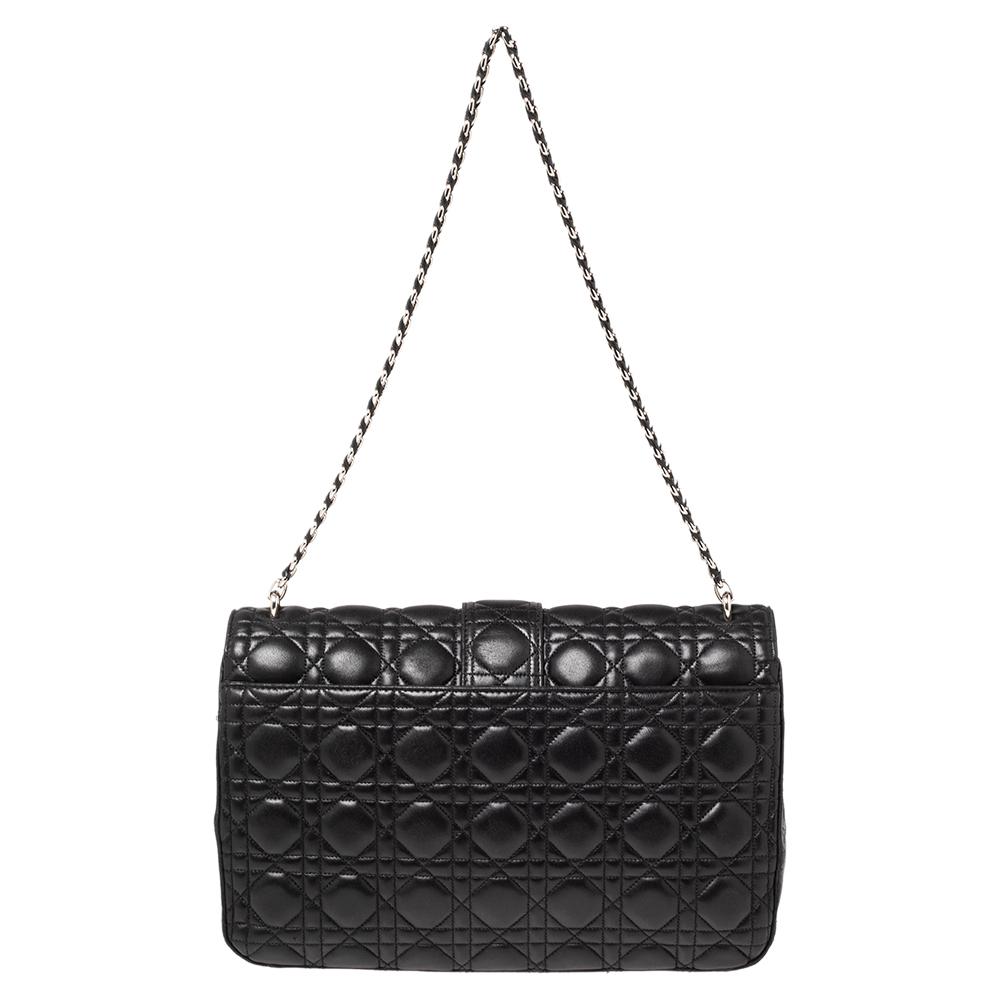 Flap bags like this Miss Dior will never go out of style. Crafted from leather, this Dior bag features a black exterior with the signature Cannage quilted exterior and a chain-link strap. The front flap has a push lock that opens to a leather-lined