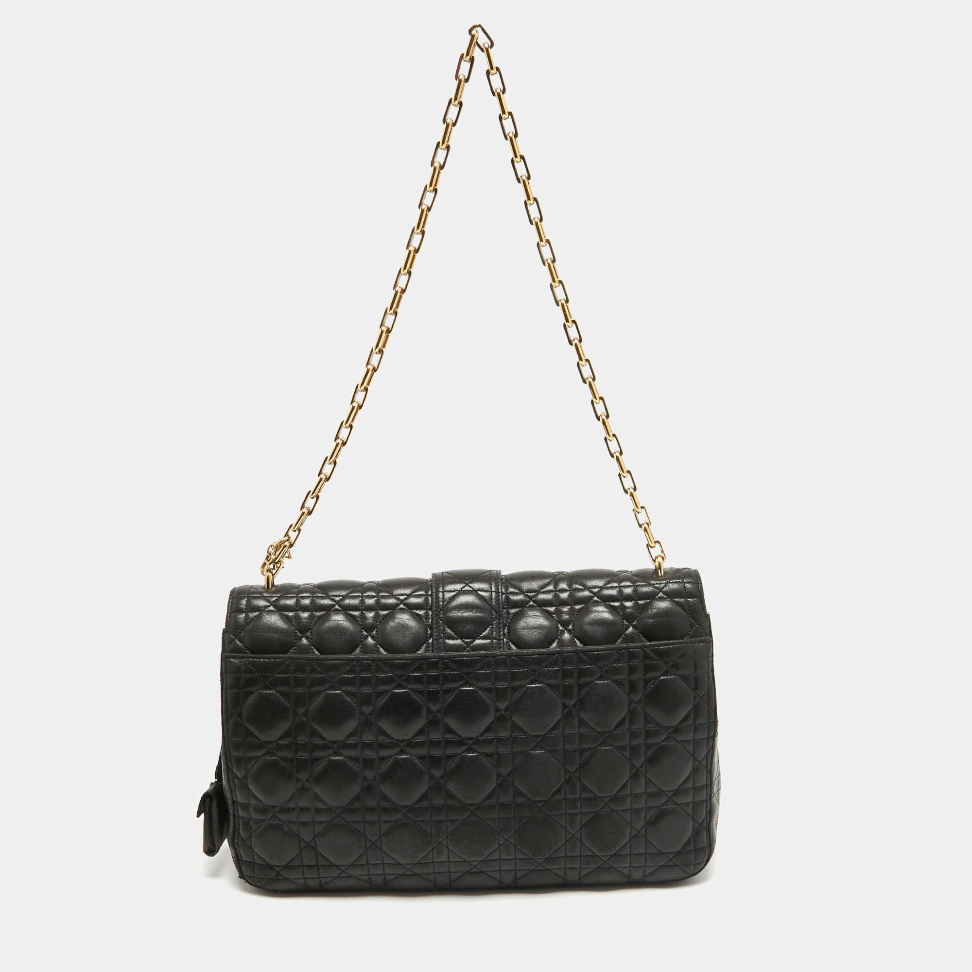 Ce sac Miss Dior de Dior, avec son design luxueux, sera un favori. Confectionné en cuir, il est orné de détails Cannage et de ferrures dorées. Ce sac est doté d'une chaîne d'épaule pour vous permettre de garder les mains libres.

Comprend : Clé