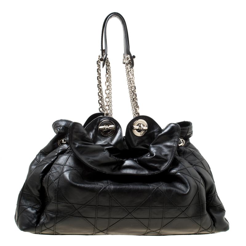 This stylish Le Trente hobo from Dior has been crafted from black leather and styled with their signature cannage pattern. The bag features dual chain straps with leather shoulder rest, a CD cutout charm, a drawstring closure and protective metal