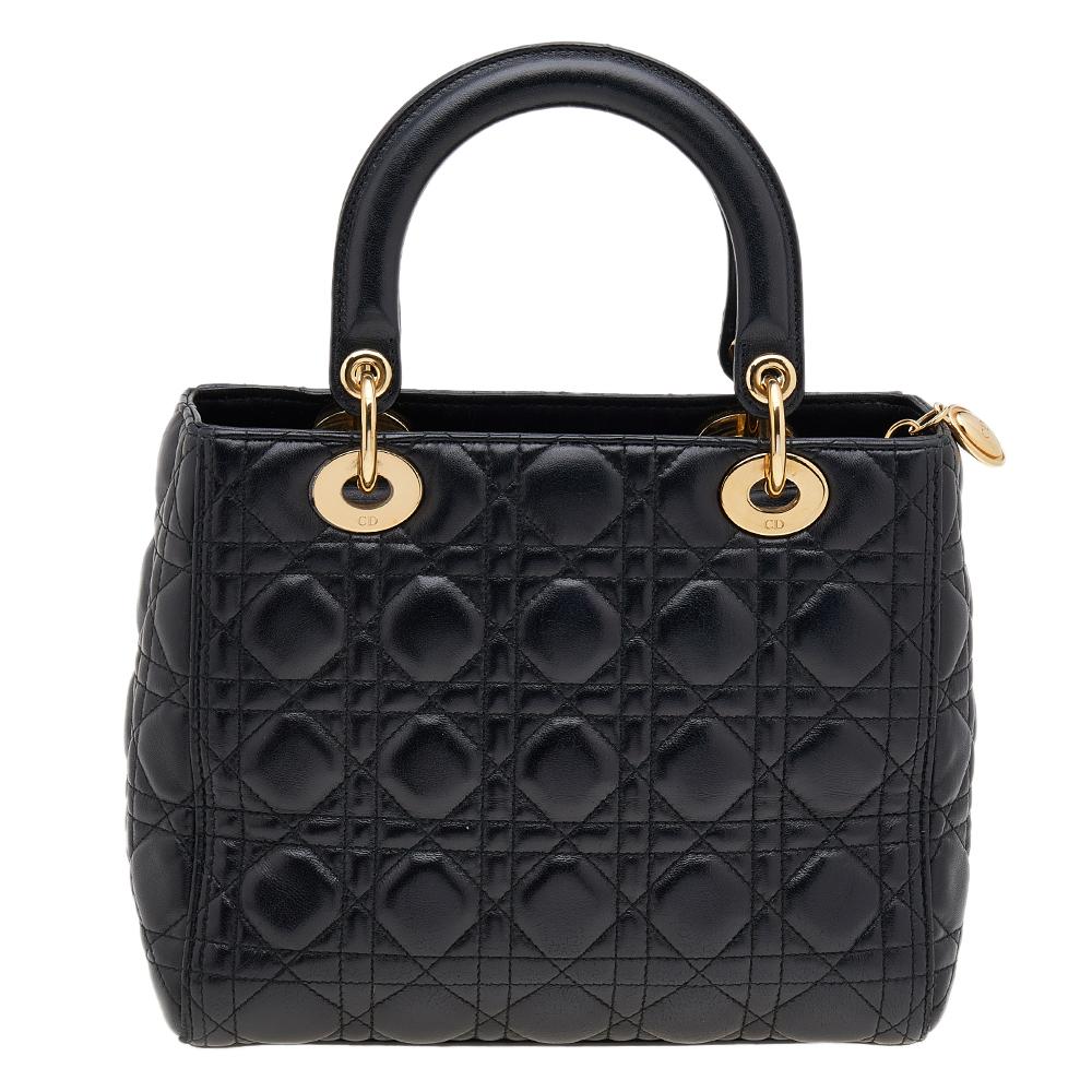 A timeless status and great design mark the Lady Dior tote. It is an iconic bag that people continue to invest in to this day. We have here this medium Lady Dior tote crafted from black patent leather. The bag is complete with two top handles, a