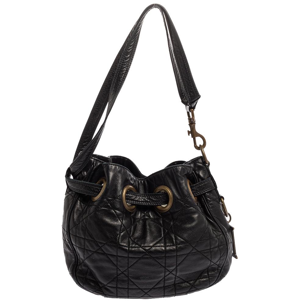 Chic bags like this Miss Dior will never go out of style. Crafted from leather, this Dior bag features a black Cannage exterior and a single shoulder strap. It has a top drawstring closure that opens to a fabric-lined interior with enough space to