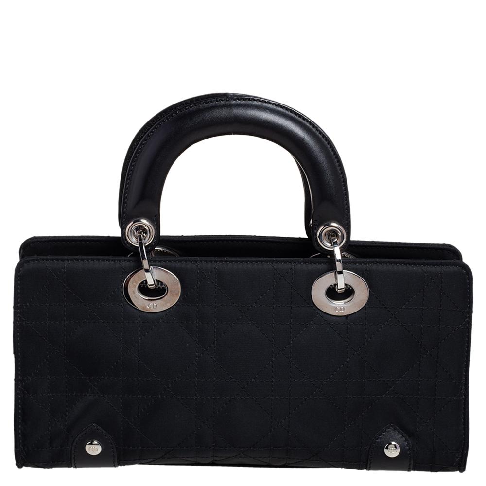 Flaunt rich taste and class with this Lady Dior tote. This special Dior creation has a structured body crafted from cannage quilted nylon & leather and features well-sized fabric interiors secured by a zipper in silver-tone hardware. With two top