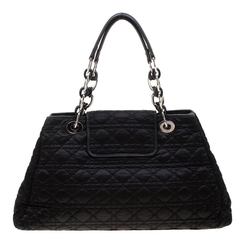 This elegantly designed Dior Charming Lock satchel is ideal for all casual and formal outings. Crafted from black nylon with leather trim, it features Dior’s classic cannage quilted pattern all over, a stylish twist lock, D.I.O.R silver charms,