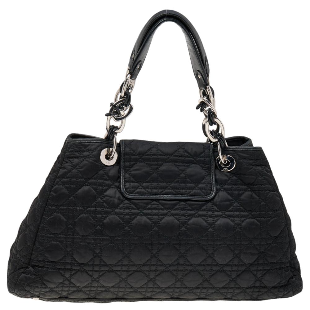 This elegantly designed Dior Charming Lock satchel is ideal for all casual and formal outings. Crafted from black nylon, it features Dior’s classic Cannage quilted pattern all over, a stylish twist lock, D.I.O.R charms, chain link and leather