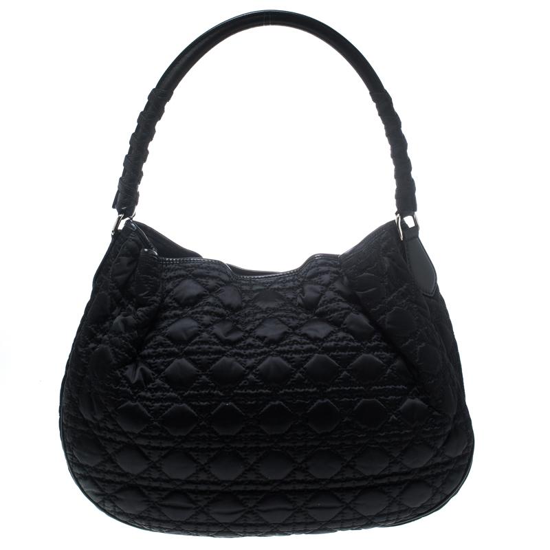 This Lovely hobo from Dior is crafted from black nylon, it features the signature cannage pattern, single handle and Dior letter charms. The interior is sized to easily hold your daily necessities. High on appeal and effortlessly stylish, this hobo