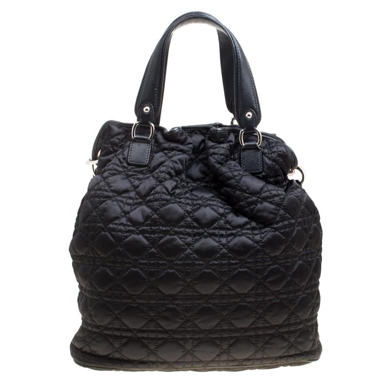 This chic and feminine tote is from Dior and is crafted from nylon and leather. Black in colour, it is easy to carry around. It features dual handles with the signature 'DIOR' accents and the interior is fabric lined and sized to fit your daily