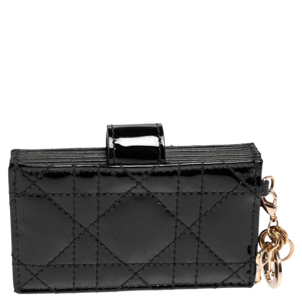 The Lady Dior gusset card case is a Dior creation that is functional, durable, and high on style! This case has been crafted from patent leather and it carries the signature Cannage quilt. It features a front cross-over flap and opens to a nylon