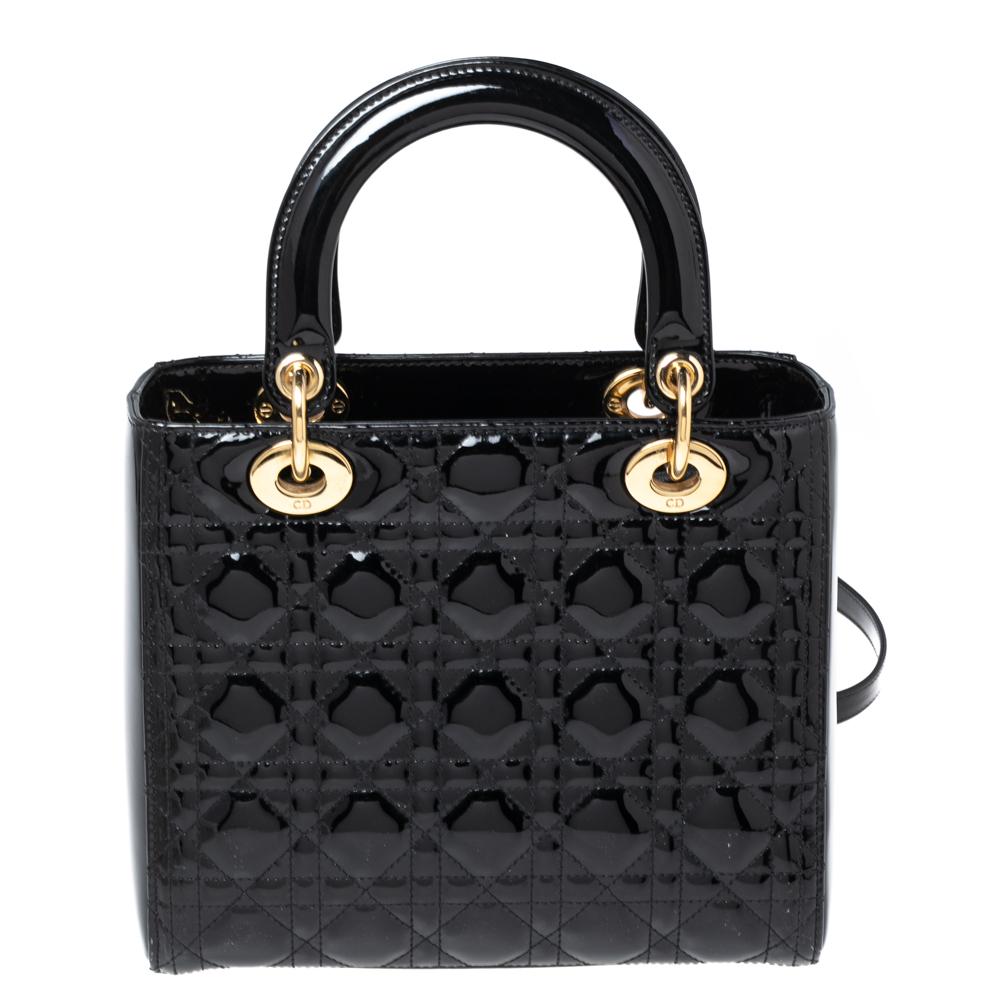 A timeless status and great design mark the Lady Dior tote. It is an iconic bag that people continue to invest in to this day. We have here this medium Lady Dior tote crafted from black patent leather. The bag is complete with two top handles, a