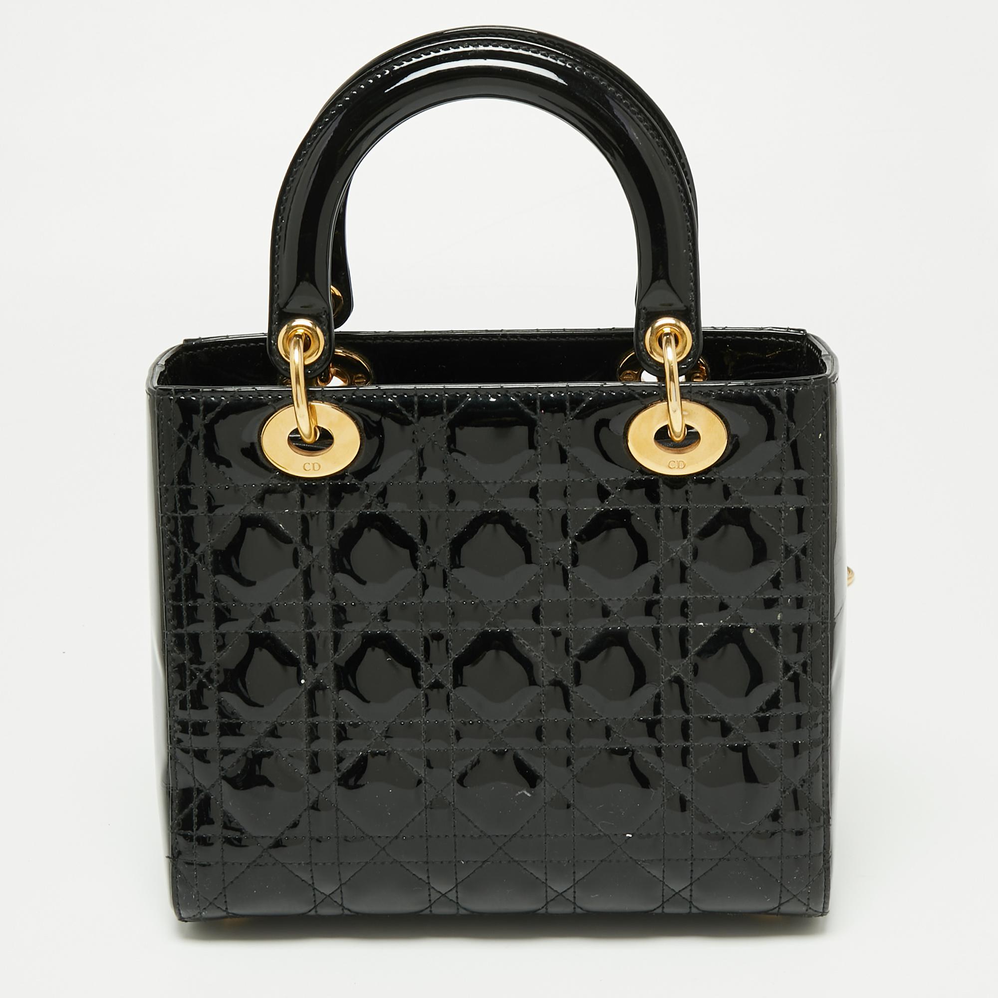 The Lady Dior tote from the house of Dior is a must-have among fashionistas. This black tote has been crafted from patent leather and it carries the signature Cannage quilt. It is equipped with a roomy interior and two top handles. The gorgeous