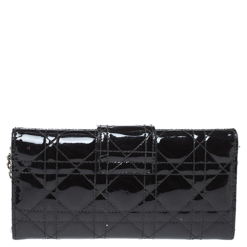 Dazzling in a gorgeous black shade, this Dior wallet on chain is crafted from patent leather in their Cannage pattern and designed with a front flap that is detailed with a silver-tone lock. The leather and nylon-lined interior houses a zip pocket,