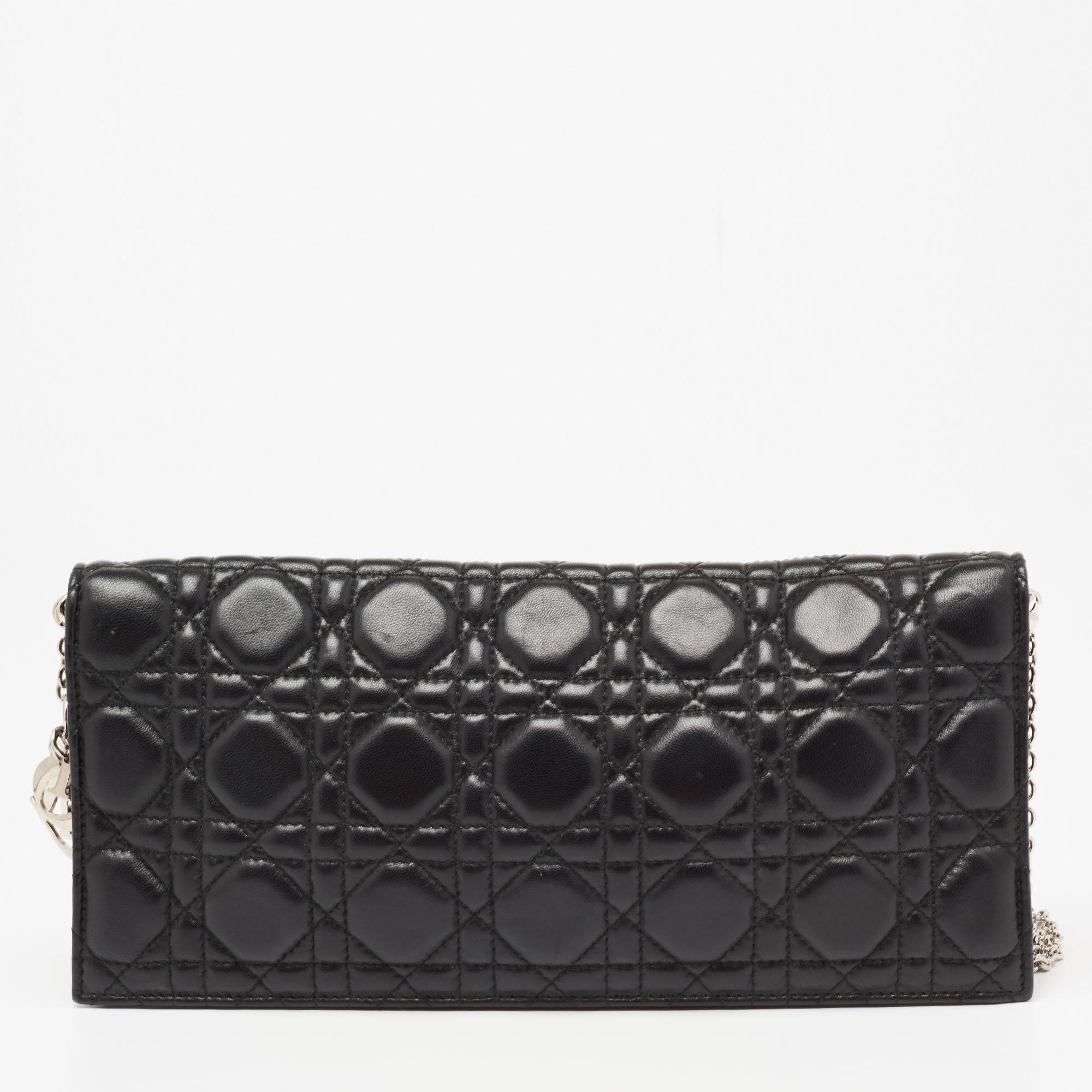 This Lady Dior chain clutch from the House of Dior is a stylish creation that is exceptionally well-made. Crafted from black Cannage quilted leather, this clutch is embellished with silver-tone hardware. It unveils a fabric-lined interior, which can