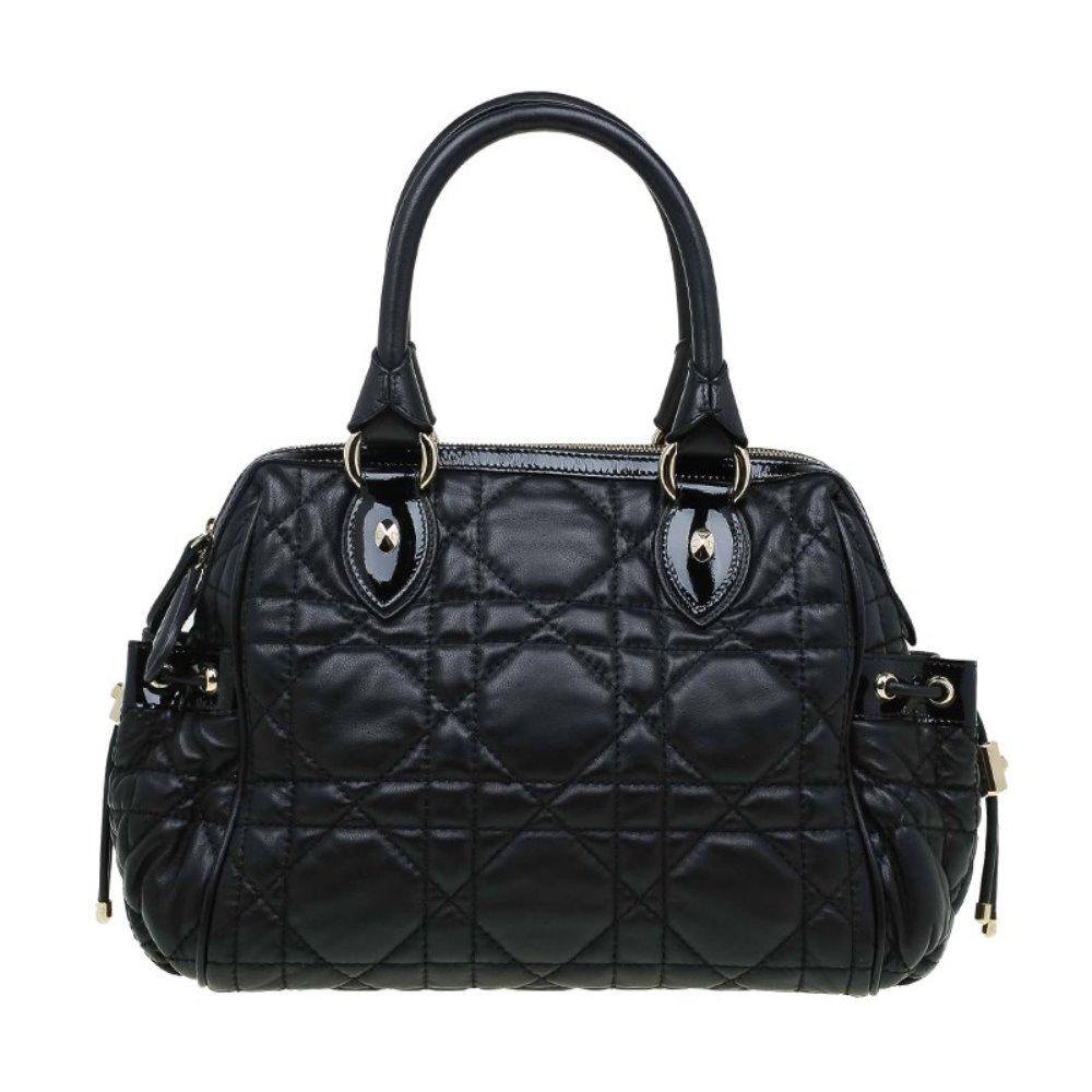 Made of leather with the signature cannage quilting, this Dior satchel is easily recognised. It has two rolled top handles so it can be draped easily over the arm and silver tone hardware. In addition to a spacious main compartment, it also has two