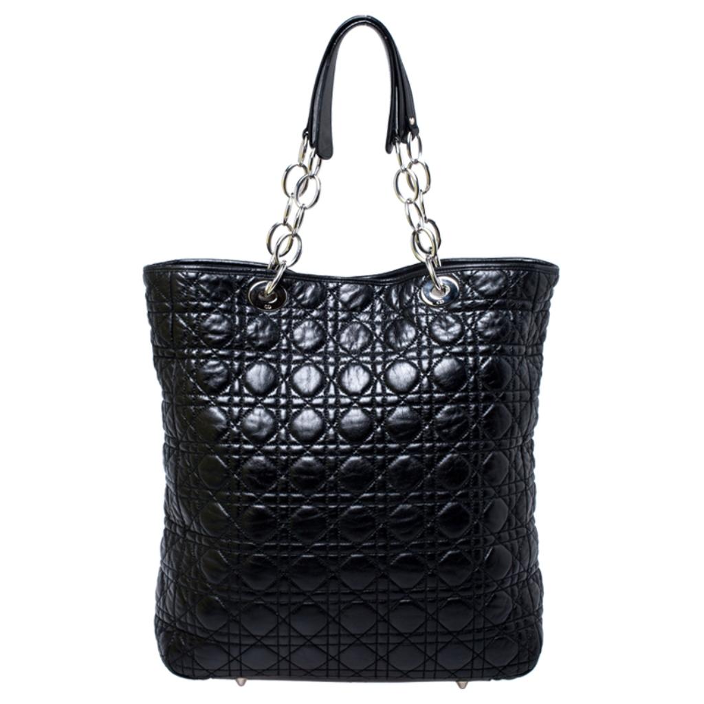 This shopper tote from Dior is a timeless piece. The bag is crafted from luxurious black leather and has the cannage pattern. It features double top handles, protective feet at the bottom and Dior letter charms in silver tone. A buttoned closure