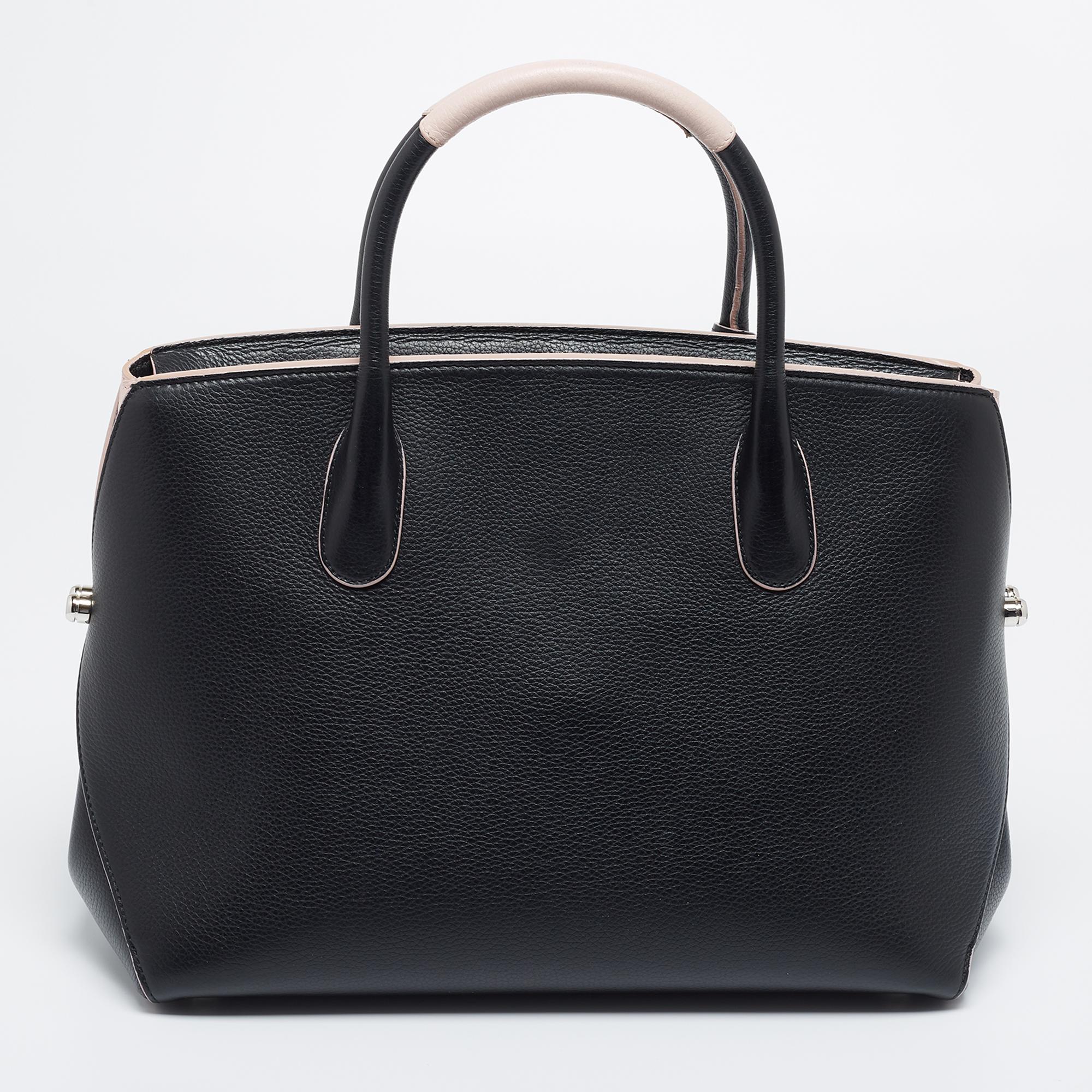 The sculptural silhouette of this Dior Open Bar tote makes it desirable and elegant. Lined with leather, the spacious interior can perfectly accommodate your daily essentials. It can be conveniently carried with the dual handles at the top and the
