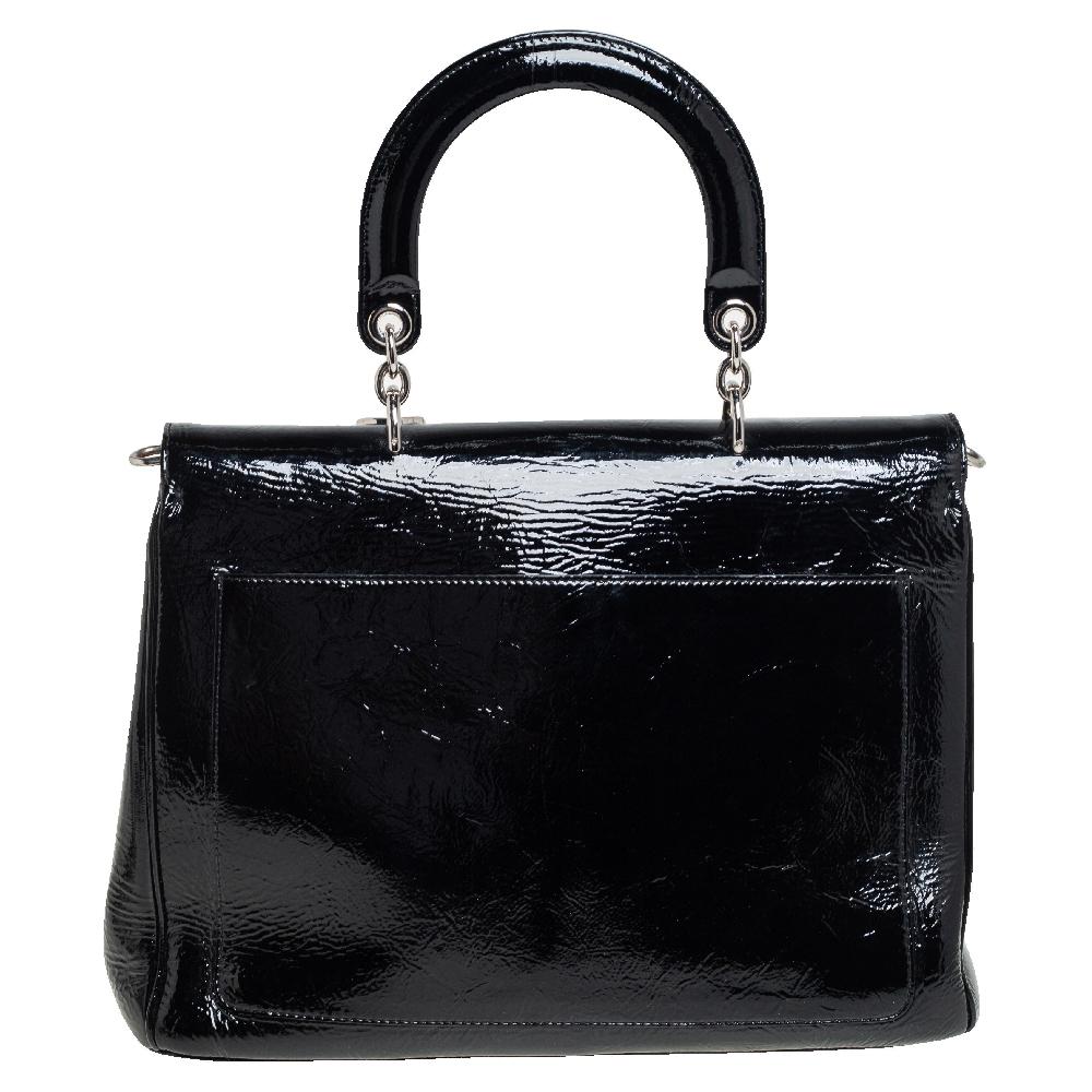 This Be Dior bag from the house of Dior is sure to add sparks of luxury to your wardrobe! It is crafted from crinkled leather and features a chic silhouette. It flaunts a single rolled top handle with attached 'DIOR' letter charms and comes equipped
