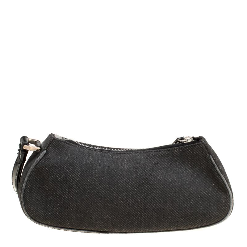 Cute and compact, this Motorcycle Rockabilly wristlet clutch from Dior is perfect for your chic style. The black creation is crafted from denim and leather and features a round motif that resembles a red light. It has a top zip closure that opens to