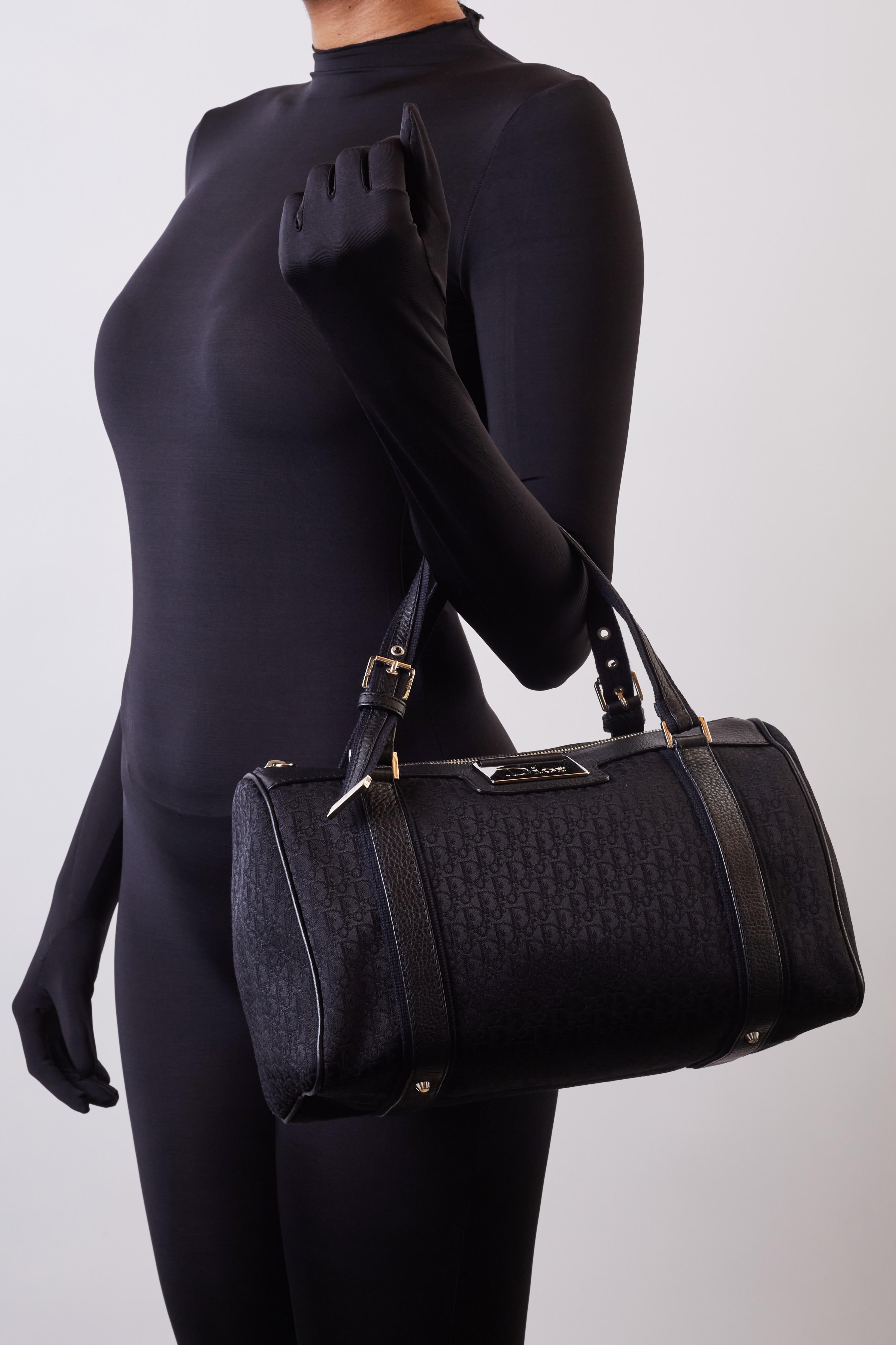 This Dior Boston 35 bag in black oblique monogram print measures 30 cm (12 inches) and is constructed of canvas with leather details and finishes. The bag is part of Galliano’s street chic collection, 2006. The bag features dual flat woven fabric