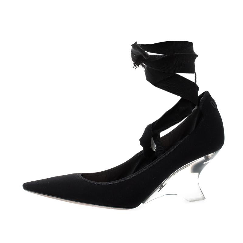 Experience the best of fashion with these spectacular black pumps from Dior. The pumps are crafted from fabric and feature a sophisticated silhouette. They flaunt pointed toes, ankle wrap straps, leather-lined insoles and heels detailed with