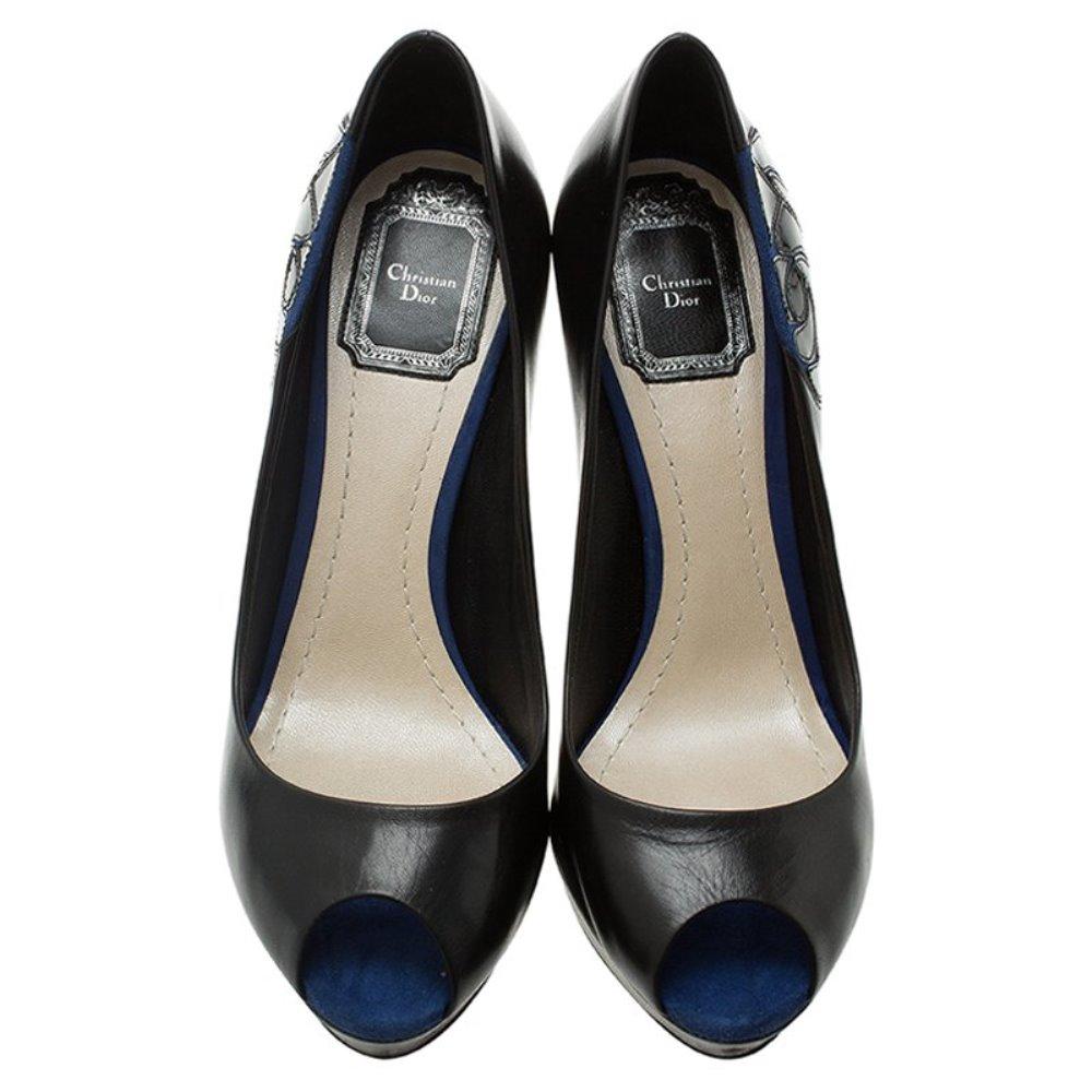 These beautiful Dior pumps are simple and elegant. They are crafted from black leather and blue suede and feature peep toe caps, platforms, rose detail on their sides, and CD hardware on their backs. They are lined with leather and have Christian