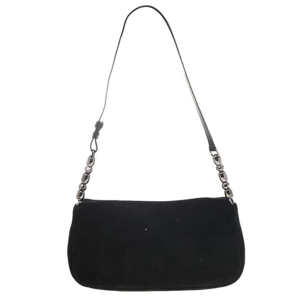 Every modern-day wardrobe needs a Dior handbag like this. A practical and elegant everyday bag in a lovely black hue, this one is made from suede and leather. It is held by a single handle, features silver-tone hardware, and comes with a well-sized
