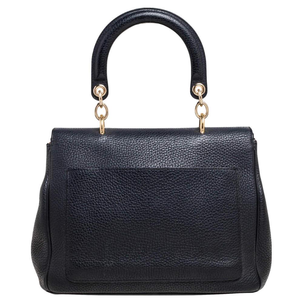 This Be Dior bag from the house of Dior is sure to add sparks of luxury to your wardrobe! It is crafted from leather into a chic silhouette. It flaunts a single top handle with attached 'DIOR' letter charms and comes equipped with protective metal