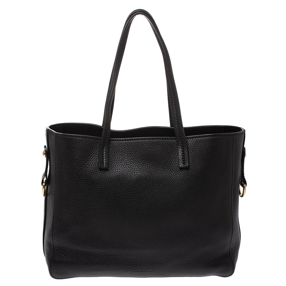 You'll surely love owning this Dior tote as it is stylish and functional. It has been crafted from black leather and styled with two handles, a shoulder strap and the brand logo with a bee motif on the front. The bag is complete with a spacious