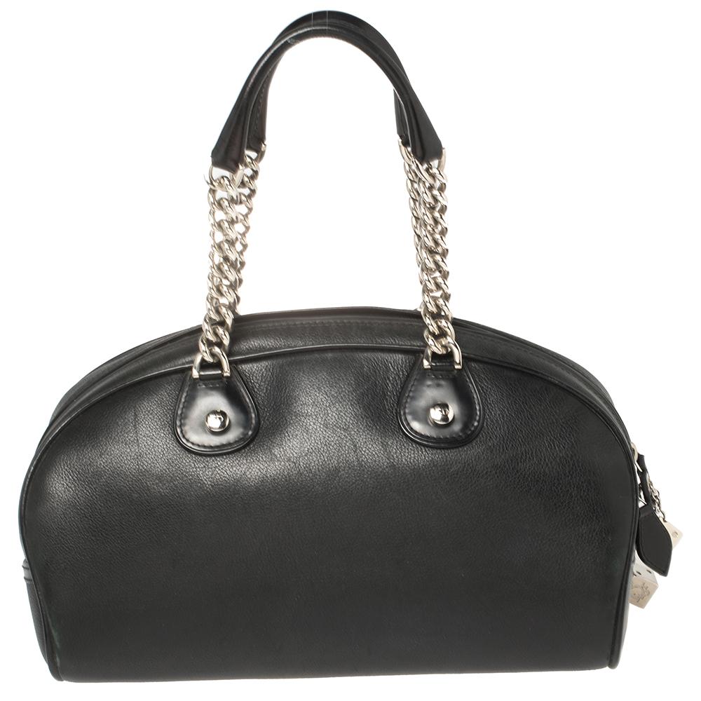 Spacious and captivating, this Gambler Dice Bowling bag is from Dior. It has been crafted from black leather and designed with dangling DIOR metal dices and two handles. The spacious nylon interior will also dutifully hold all your belongings.

