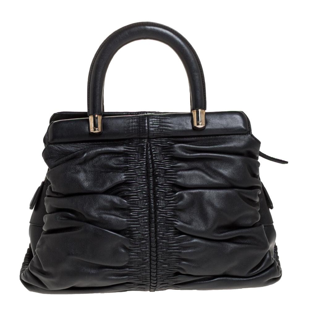 There won't ever be a day when you won't want to carry this Karenina Hermitage bag by Christian Dior. This intricately pleated bag is crafted from black leather and designed with a CD detail and framed top handles. The fabric-lined interior will
