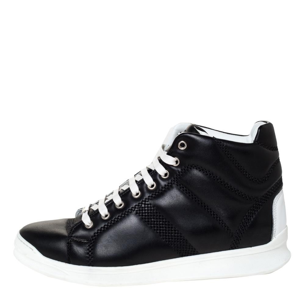 These stylish and trendy high-top sneakers by Dior deliver street style and maximum comfort. Crafted meticulously from quality leather, they come in a classic shade of black. They are styled with lace-up vamps with contrasting laces. They carry the