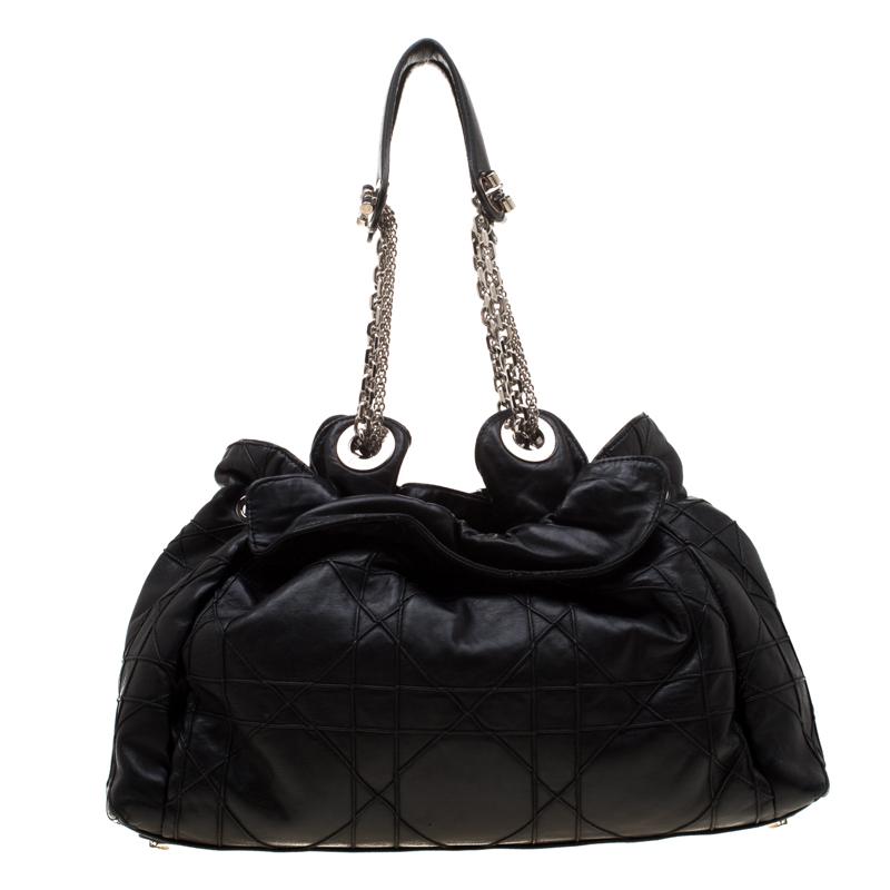 This stylish Le Trente hobo from Dior has been crafted from black leather and styled with their signature cannage pattern. The bag features dual chain handles with leather shoulder rests, a CD cutout charm, a drawstring closure and protective metal