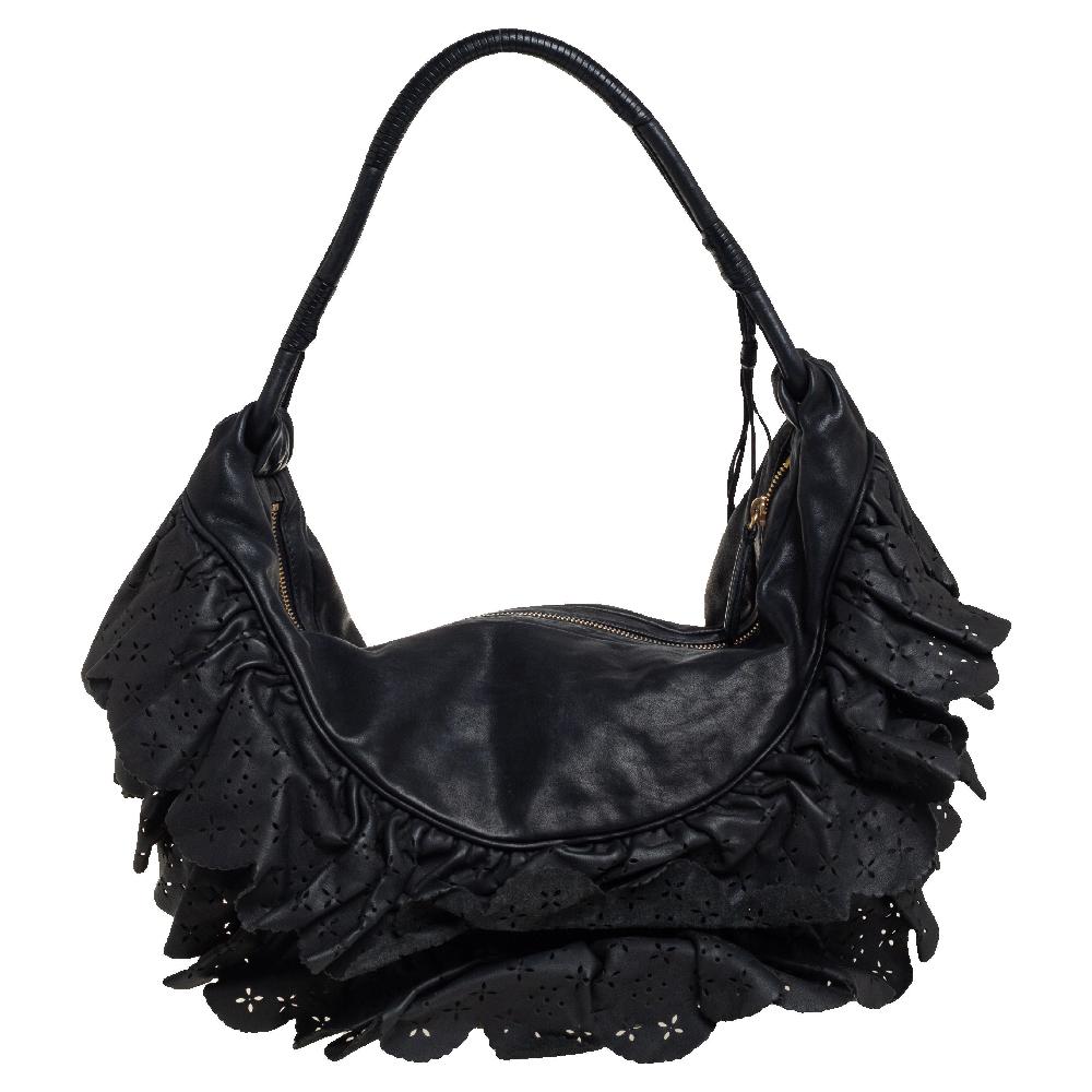 This Dior Gypsy hobo is a gorgeous and feminine handbag that you can wear daily. The lovely black leather exterior is accented with leather ruffles in a lace pattern with delicate cut outs. The bag comes with gold-tone D.I.O.R charms and a leather