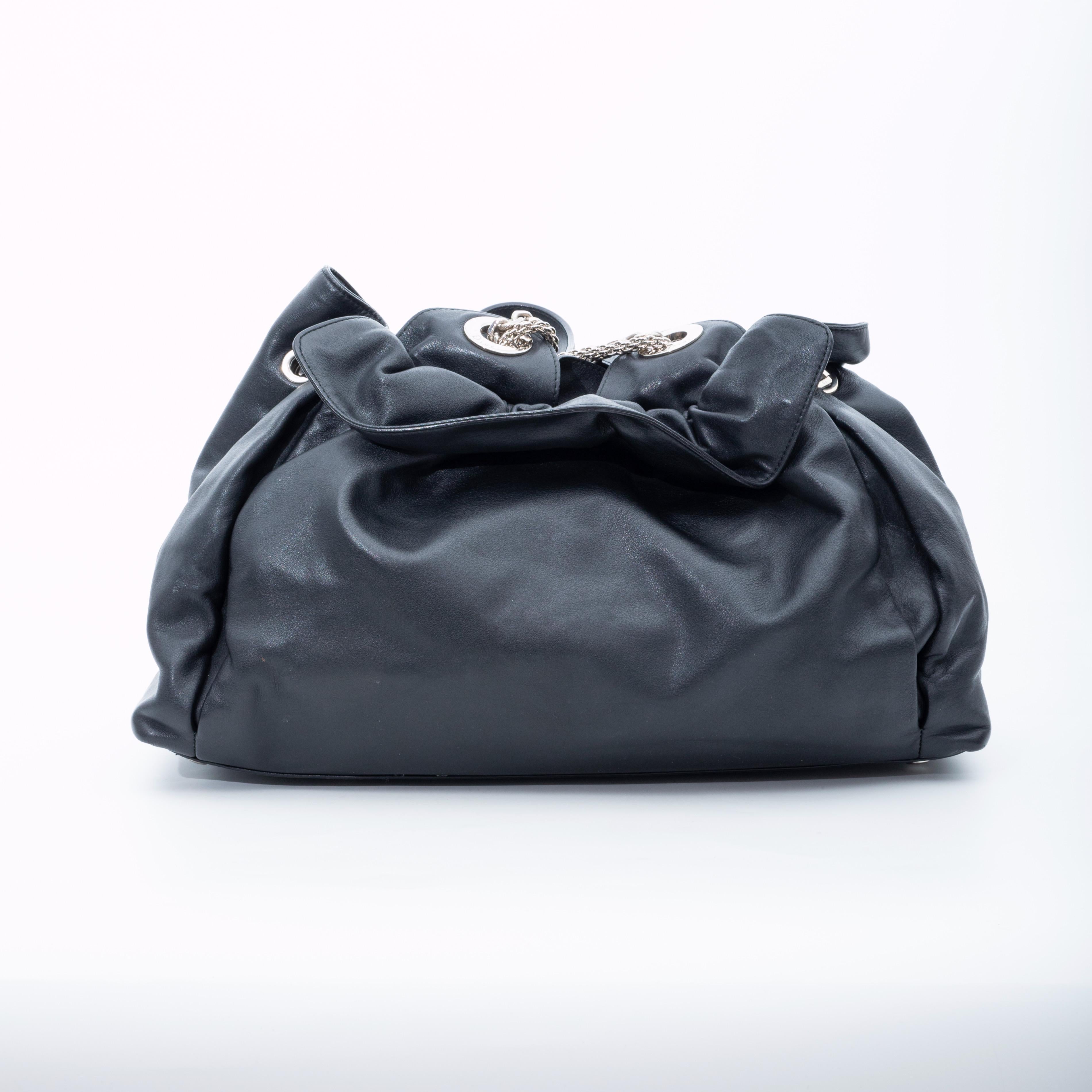 The Le Trente features a leather body, curb chain straps, a top magnetic snap closure and an interior zip pocket.

COLOR: Black
MATERIAL: Leather
ITEM CODE:17-B0-0029
MEASURES: H 9” x L 16” x D 6”
DROP: 10”
COMES WITH: Dust bag
CONDITION: Good -