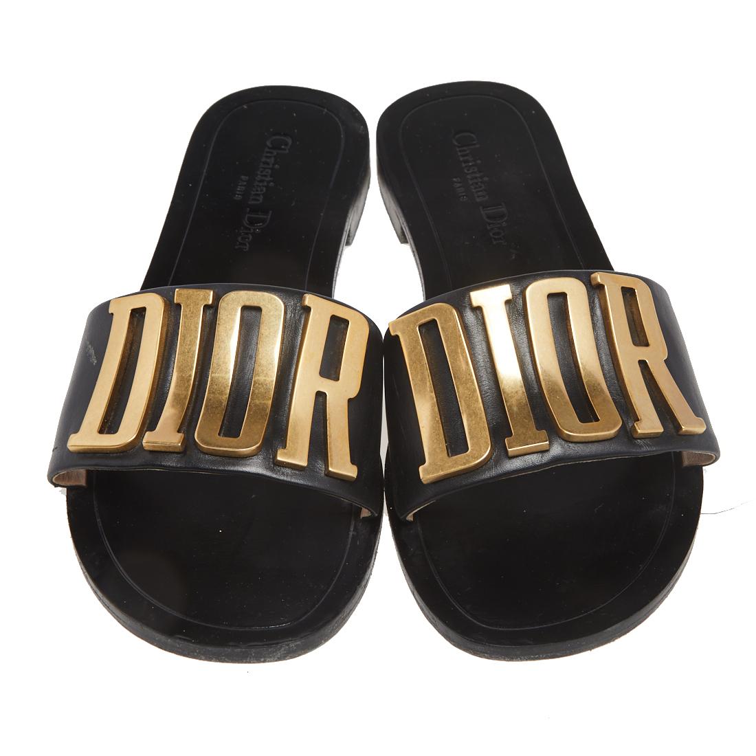 These sandals by Dior are trendy and easy to slip on. Made in Italy, they feature gorgeous black uppers that carry the famous brand name in gold-tone metal. They are fashioned from luxurious black leather and set on low heels. Just slip them on and