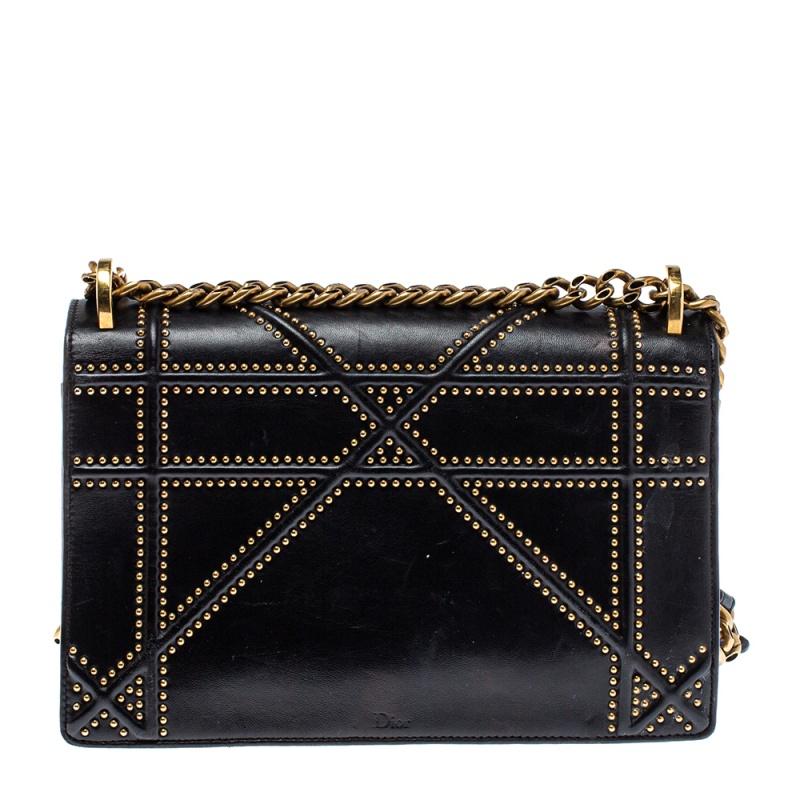 This Diorama bag is simply breathtaking! From its structured shape to its artistic craftsmanship, the bag sweeps us off our feet. It has been crafted from black leather and covered in the brand's signature Cannage pattern, outlined with gold-tone