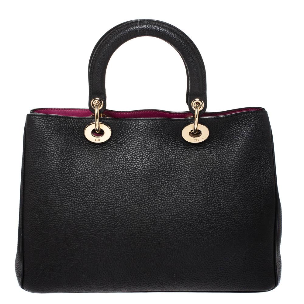 The Diorissimo shopper tote from Dior is a piece that has never gone out of style. The leather bag comes in a pleasing black shade with gold-tone hardware and Dior letter charms. It features double top handles, a small pouch and protective feet at