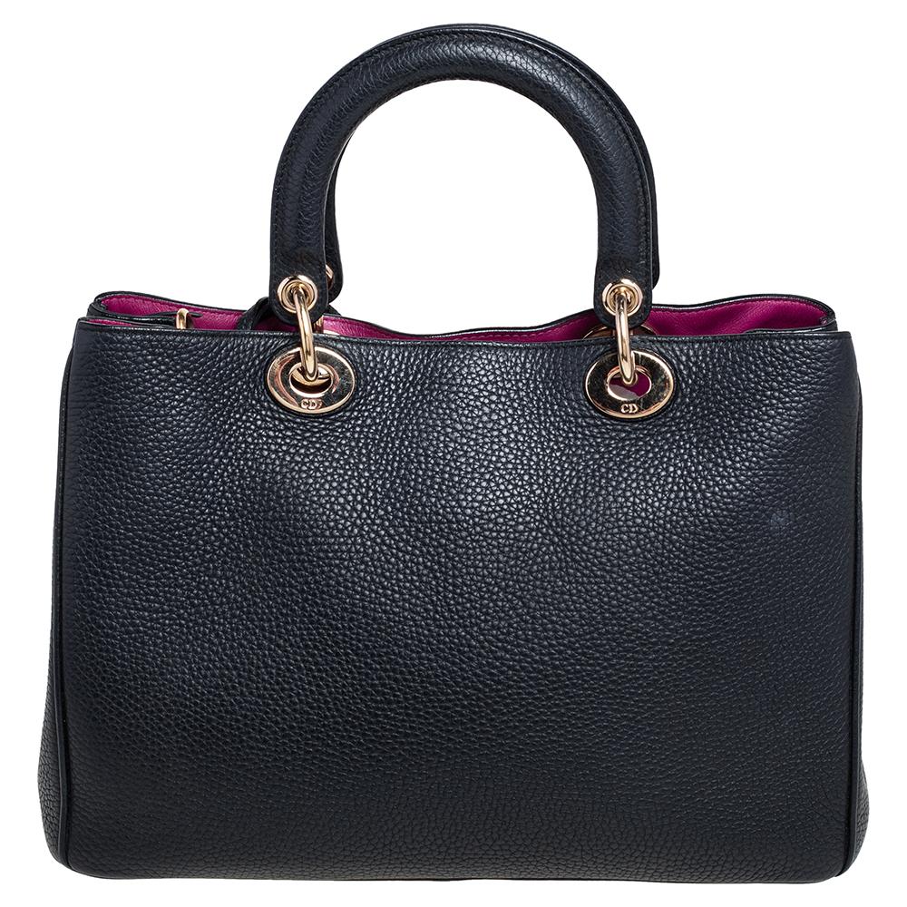 The Diorissimo shopper tote from Dior is a piece that has never gone out of style. The leather bag comes in a classic black shade with gold tone hardware and Dior letter charms. It features double top handles, a small pouch, and protective feet at