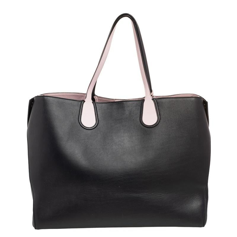 This Open Bar tote from Dior is designed to assist you with style and practical ease! It comes crafted from leather and features dual top handles. It carries the 'DIOR' letter charms within a clochette and its top opens to a spacious interior that