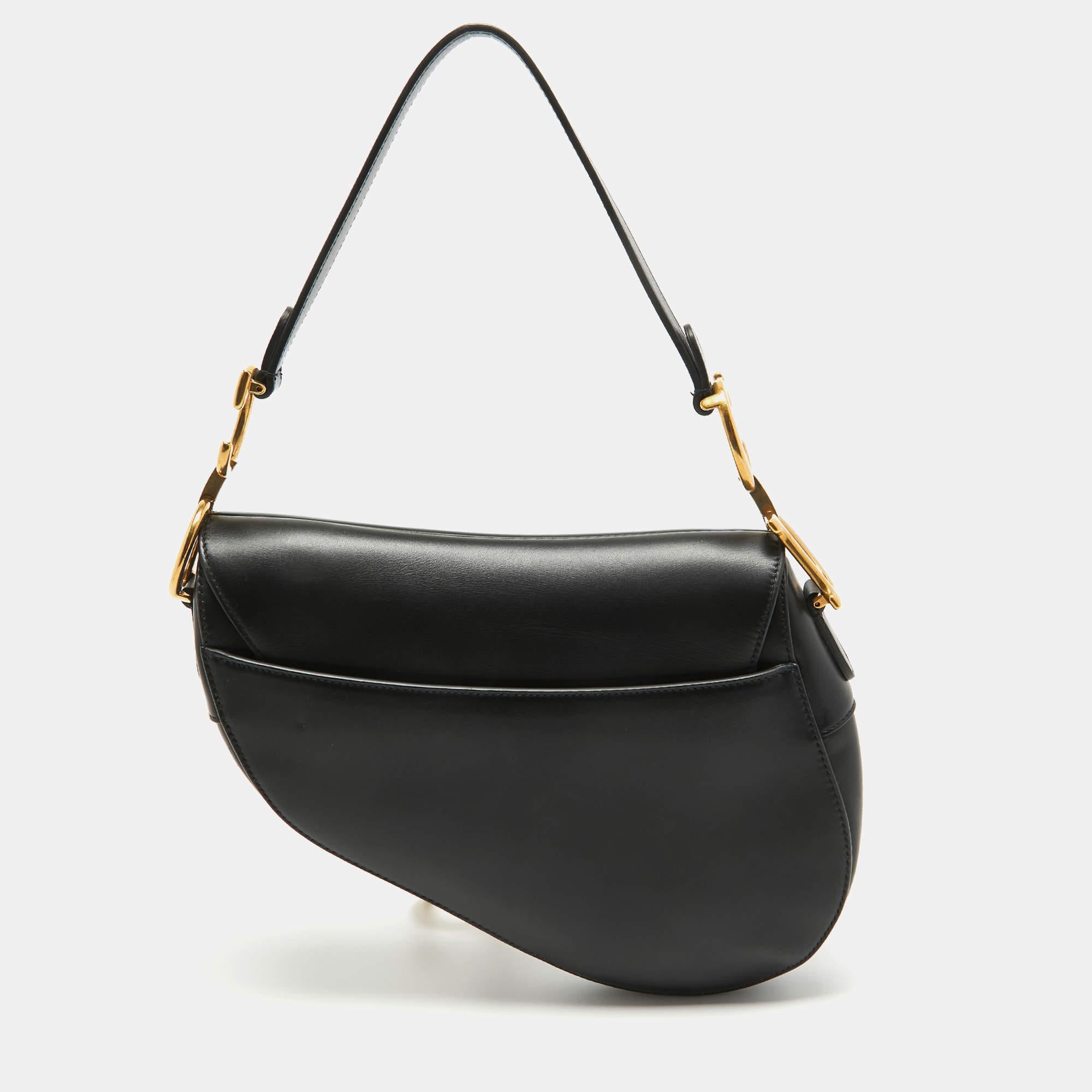 An example of timeless style and great design ideas, Dior's Saddle bag is sought after for all the right reasons. This Saddle bag for women is crafted using black leather in the iconic shape and it has gold-tone CD letters to hold the single handle