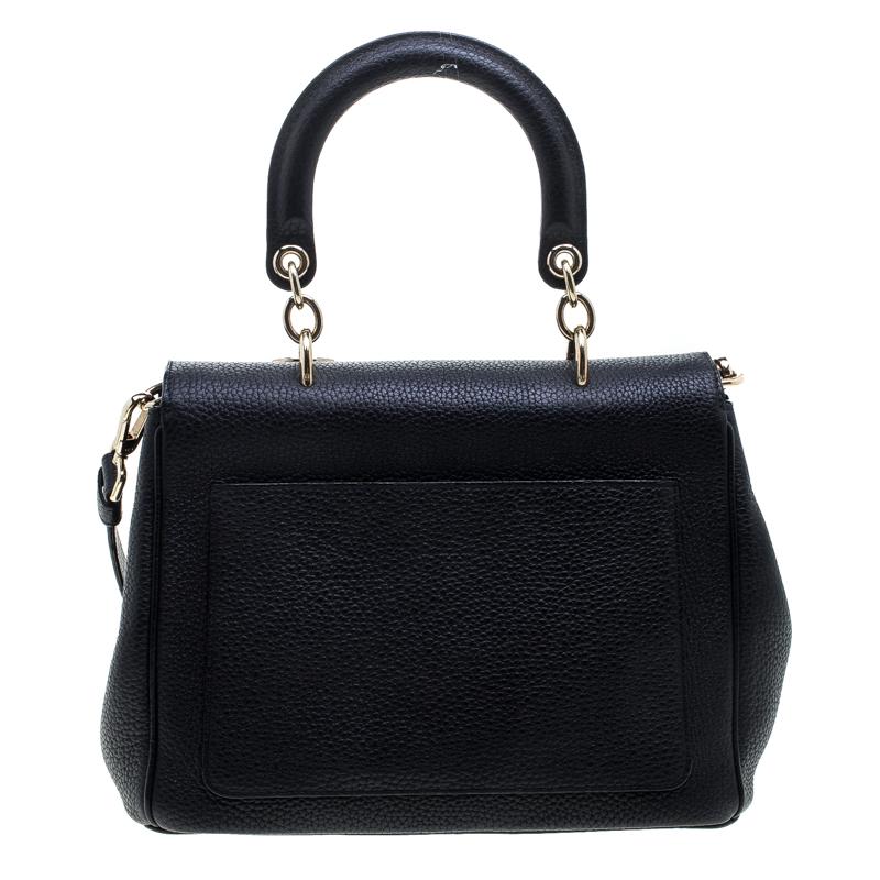 This Be Dior beauty has been meticulously crafted from leather and it features a single rolled red top handle, a removable shoulder strap, protective metal feet at the bottom and classic Dior letter charms. The flap closure opens to a leather lined