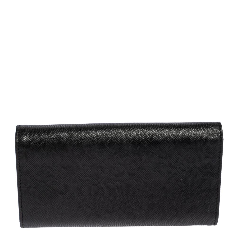 Indulge in a feel of luxury with this Dior Turn Me Dior wallet in a black hue. This stylish piece is made of high-quality leather and features a turn lock on the front flap. The beauty houses multiple card slots and a zip compartment to neatly