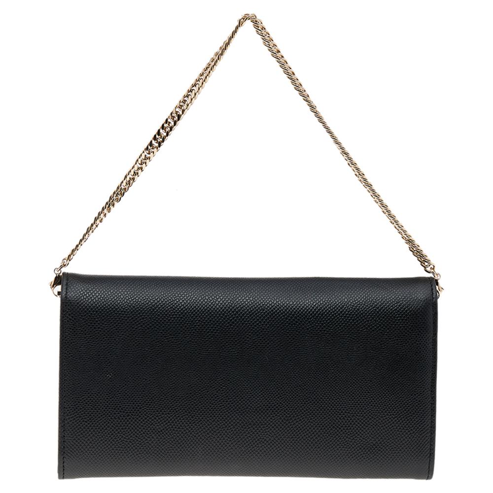 Indulge yourself in a luxurious feel with this Turn Me Dior wallet on chain from the House of Dior. It is made from black leather on the exterior with a gold-toned logo accent perched on the flap. A gold-toned chain strap completes the shape of this